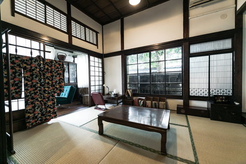 古民家の和室6畳に囲炉裏と低いテーブル、格子窓