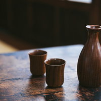 木目のテーブルに置いた徳利とお猪口の日本酒セットの写真