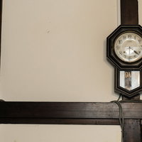 古民家の梁に掛けられた古い掛時計のの写真