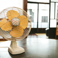 昭和の古民家に置かれたクリーム色のレトロな扇風機の写真