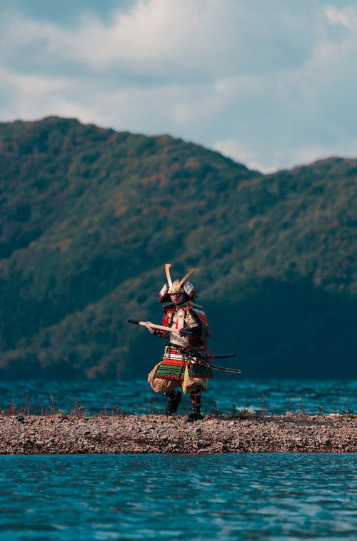 中州で棍棒を構える大鎧姿の侍男性が立つ戦闘シーン