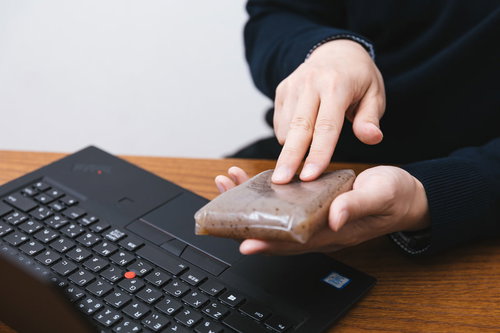 こんにゃくの表面を2本指でスクロールする男性