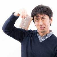 賞味期限が切れたこんにゃくから異臭がして嫌がる男性の写真