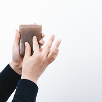 黒いスーツの男性がこんにゃくをピンチインの写真