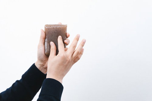 黒いスーツの男性がこんにゃくをピンチイン