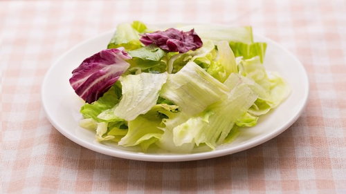 白い皿に盛られたみずみずしいサラダ、レタスと紫キャベツ