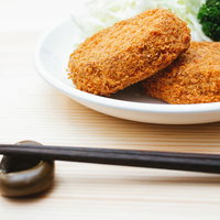 白い皿に盛られたコロッケをいただきます。揚げたてのおかずの写真