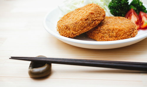 白い皿に盛られたコロッケをいただきます。揚げたてのおかず