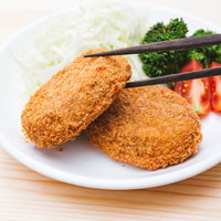 箸でつまんだコロッケを食べる揚げたての一品の写真