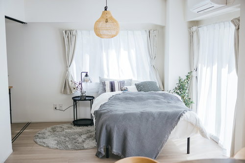 自然光が入る白とグレーの寝室のインテリア写真