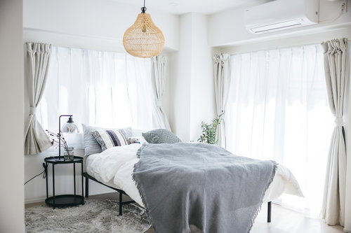 ふわふわのグレー寝具が敷かれた寝室のダブルベッド