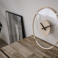 木製の台に置かれた透明なモダン時計、黒い文字盤とシンプルデザインの写真