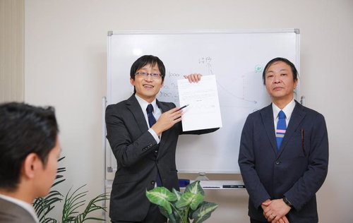 社員研修でホワイトボードの前で資料を説明する管理者