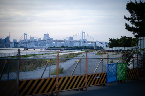 工事用ガードフェンス越しに見えるレインボーブリッジと海岸