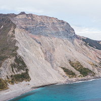 神津島の多幸浜と崩落した山の斜面の地形の写真