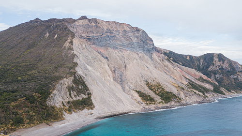 神津島の多幸浜と崩落した山の斜面の地形