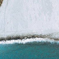 神津島の多幸浜に並ぶ消波ブロック、白い砂浜と青い海を守る防波堤の写真