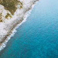 岩がゴロゴロする神津島の多幸浜海岸を空撮で捉えた景色の写真