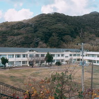 神津島村立神津小学校の白い校舎と広い校庭の写真