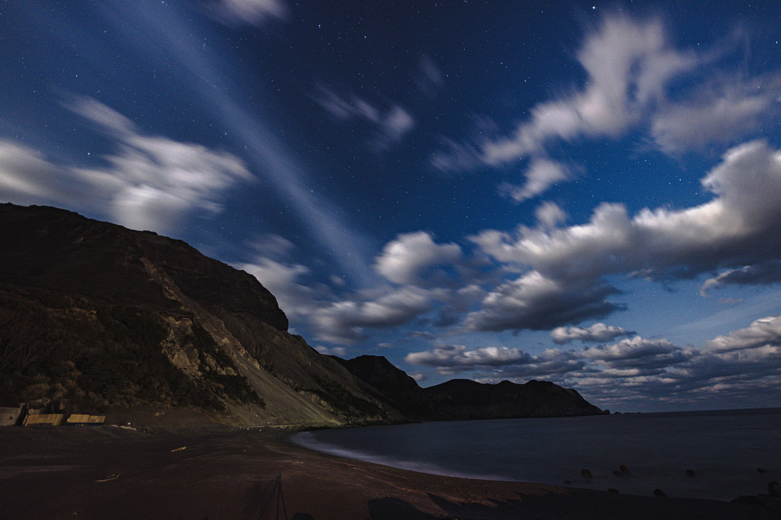多幸湾海水浴場から見た夜景、雲が流れる夜空と海岸線