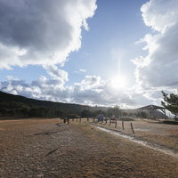 よたね広場の景観、山々を背景にした公園の広場の写真