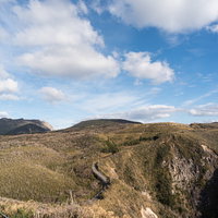 神津島灯台から望む島全体の山並みと青空の風景の写真