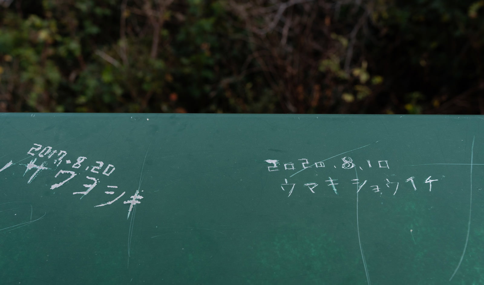 観光地の金属パネルに名前と日付を刻んだ落書き