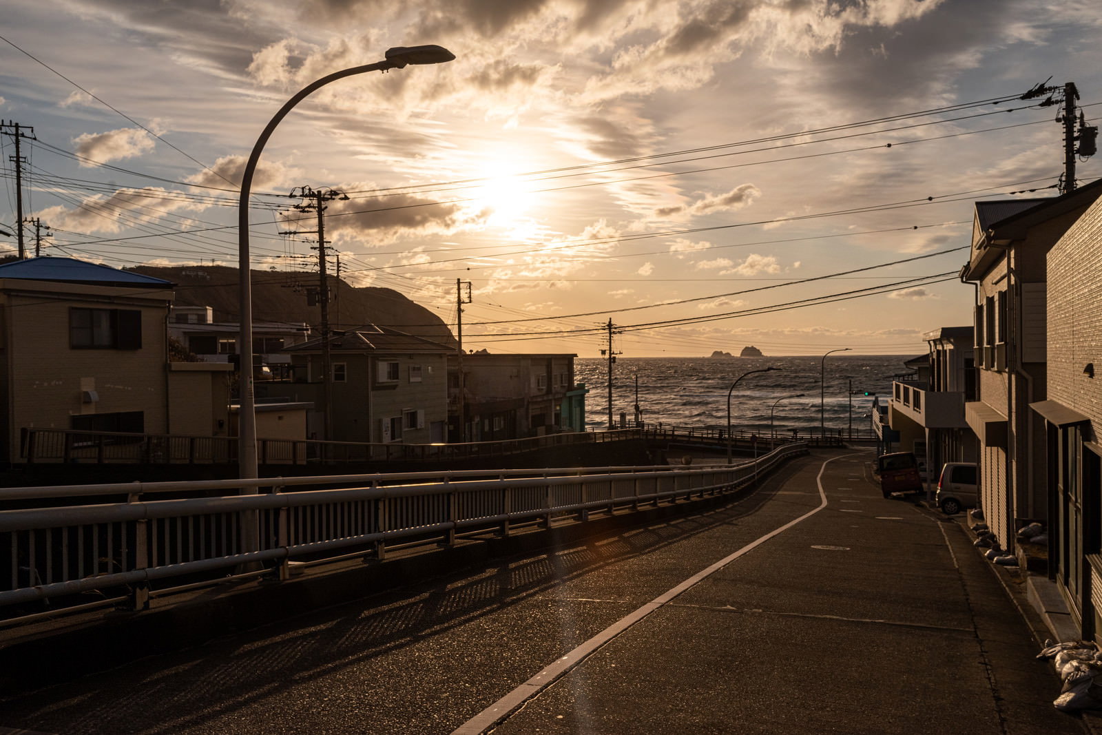 神津島の街中の道路から見上げた夕焼け空と街並みのシルエット