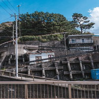 神津島の川を隔てた住宅街の坂道と青空の風景の写真