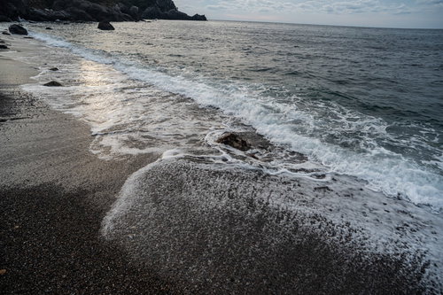 砂浜の波打ち際にザパーと打ち寄せる白い泡立つ波
