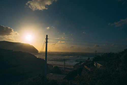 夕暮れ時に高台から眺める神津湾の海と灯台
