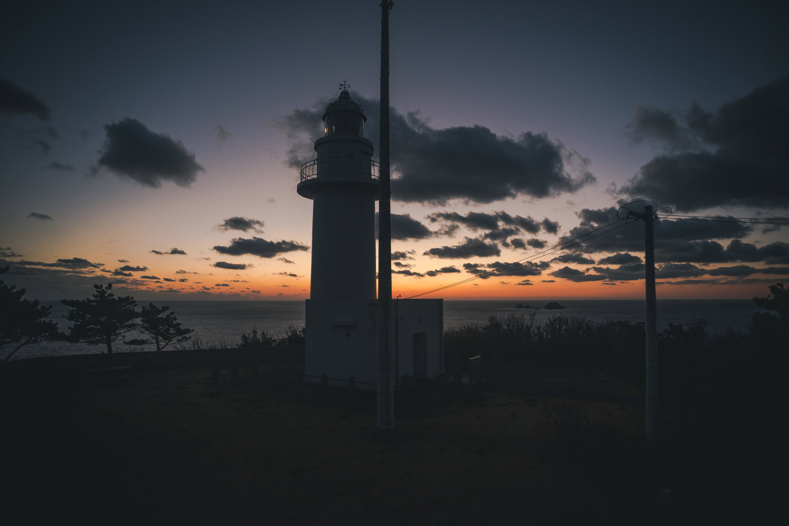 夕焼けに染まる神津島の灯台と海