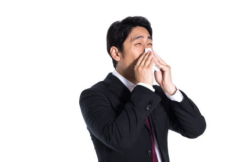 ティッシュで鼻をかむ会社員のビジネスマン