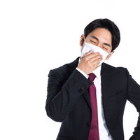 マスク着用で出社しても気分が優れない会社員男性の写真