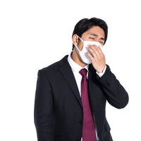 マスクを着用しても口臭が気になるスーツの会社員の写真