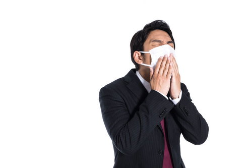 マスクを着用してもくしゃみが止まらない会社員