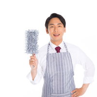 年末の大掃除中、モップを持つエプロン姿の会社員男性の写真