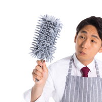 ホコリが気になる会社員がモップで清潔さをアピールの写真
