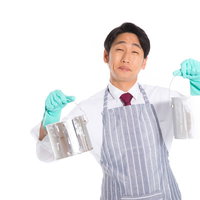 ペンキ缶を両手で持つエプロン姿の営業マンの写真