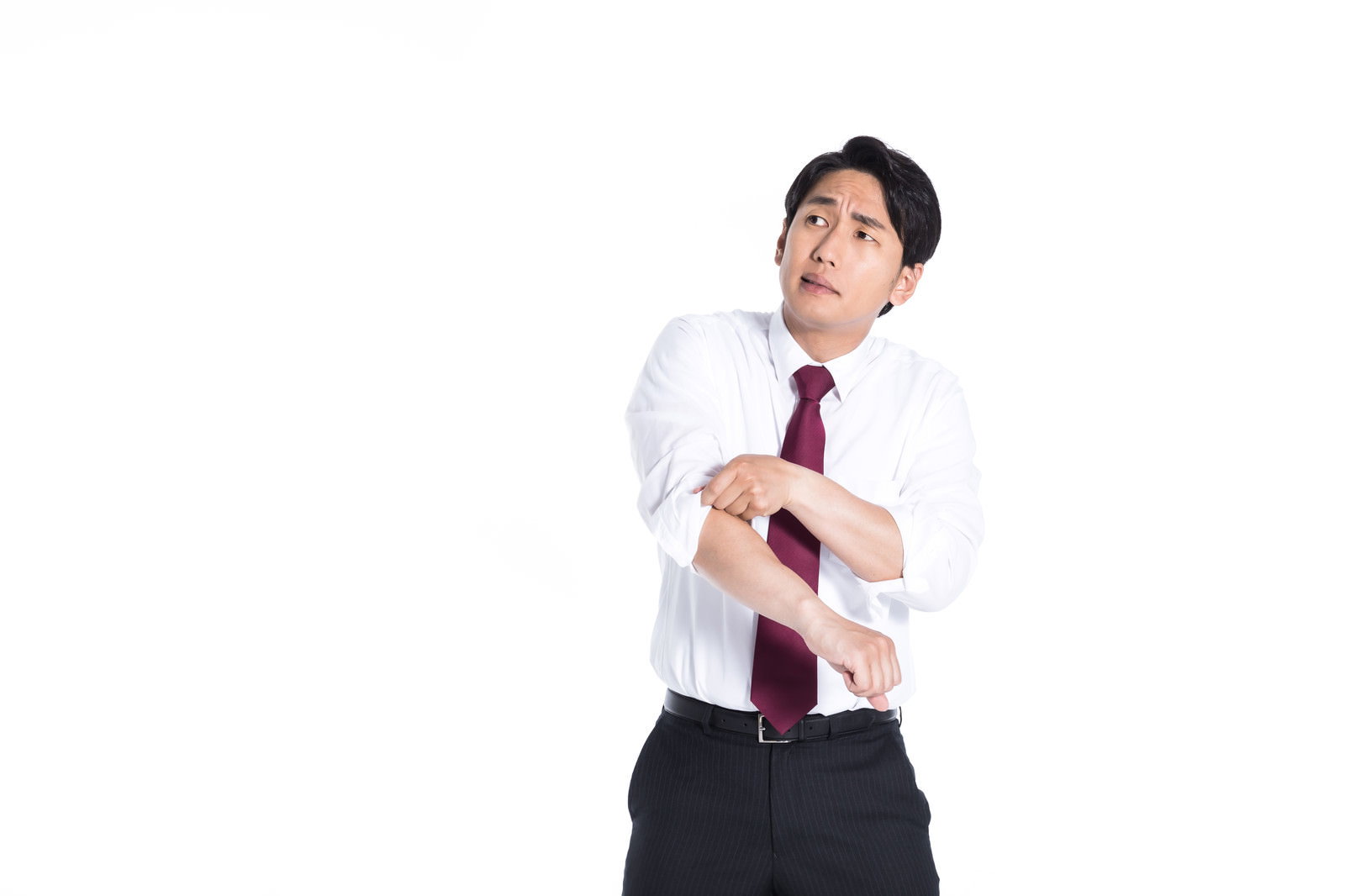 白いシャツの袖をまくり上げ、やる気に満ちた表情の会社員男性［モデル：大川竜弥］