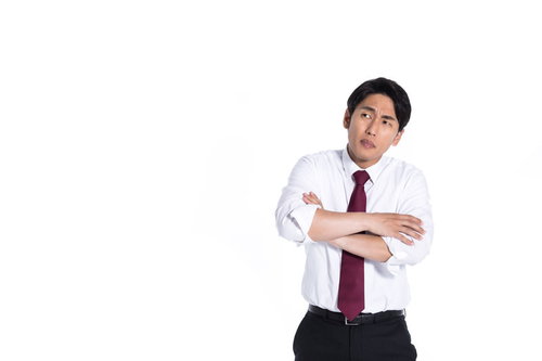 同期の成績が気になる営業担当の腕組みをするビジネスマン