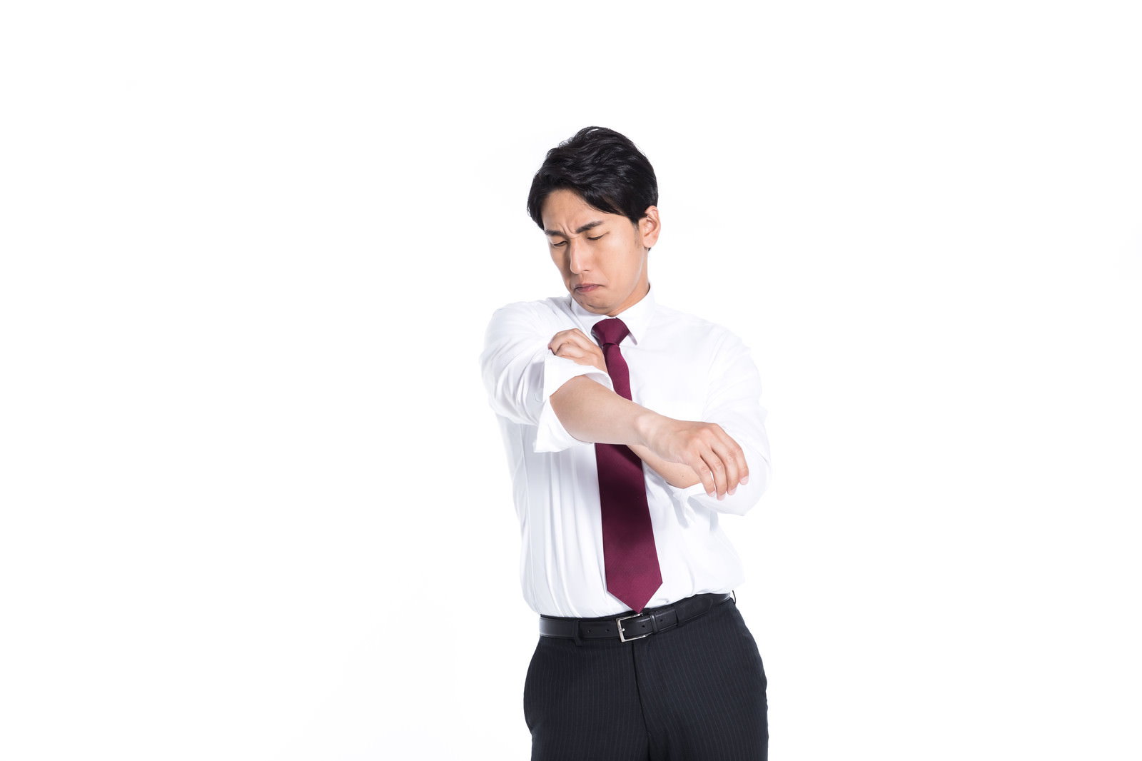 白いワイシャツの袖をまくり上げる会社員の男性［モデル：大川竜弥］