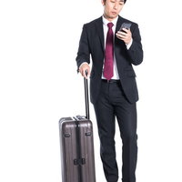 出張先までのルートをスマートフォンで検索するスーツ姿の会社員の写真