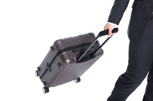 スーツケースを引いて歩く姿、転倒しやすいビジネスマン