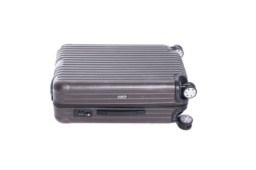 床に置かれたグレーのスーツケース、旅行・出張用のキャリーケース