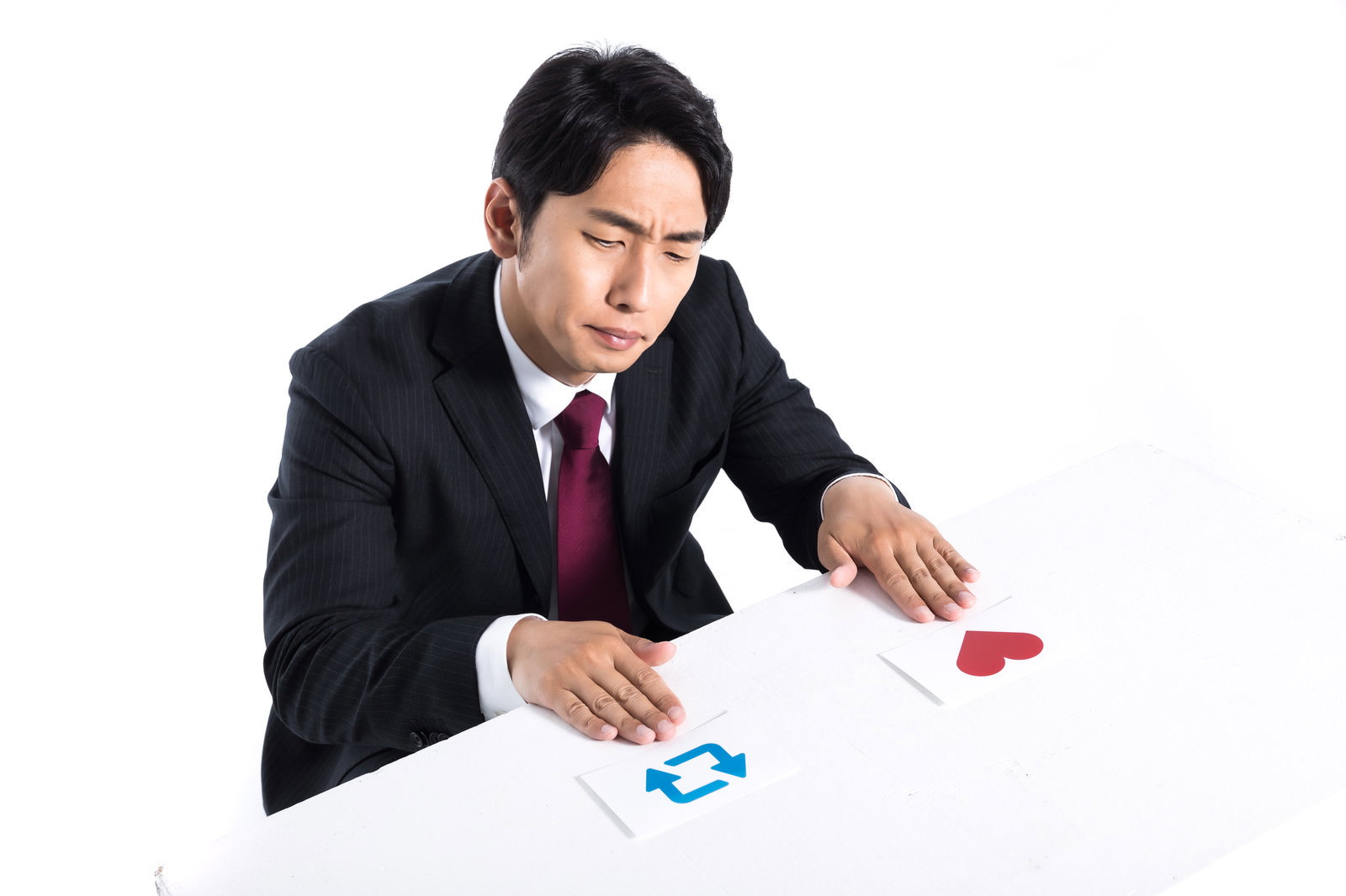 会議室で資料を見ながら困った表情を浮かべるスーツ姿の男性［モデル：大川竜弥］