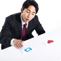 勤務中にカード選びするサラリーマン男性がクレジットカードを比較検討の写真