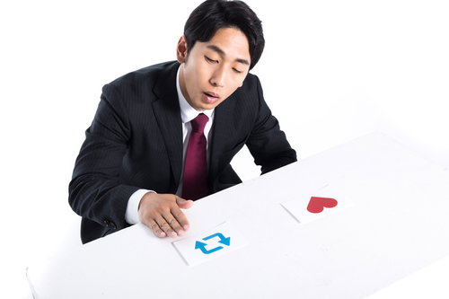 勤務中にカード選びするサラリーマン男性がクレジットカードを比較検討