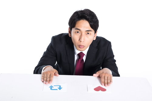 机の上の赤と青のカードで迷う会社員の意思決定