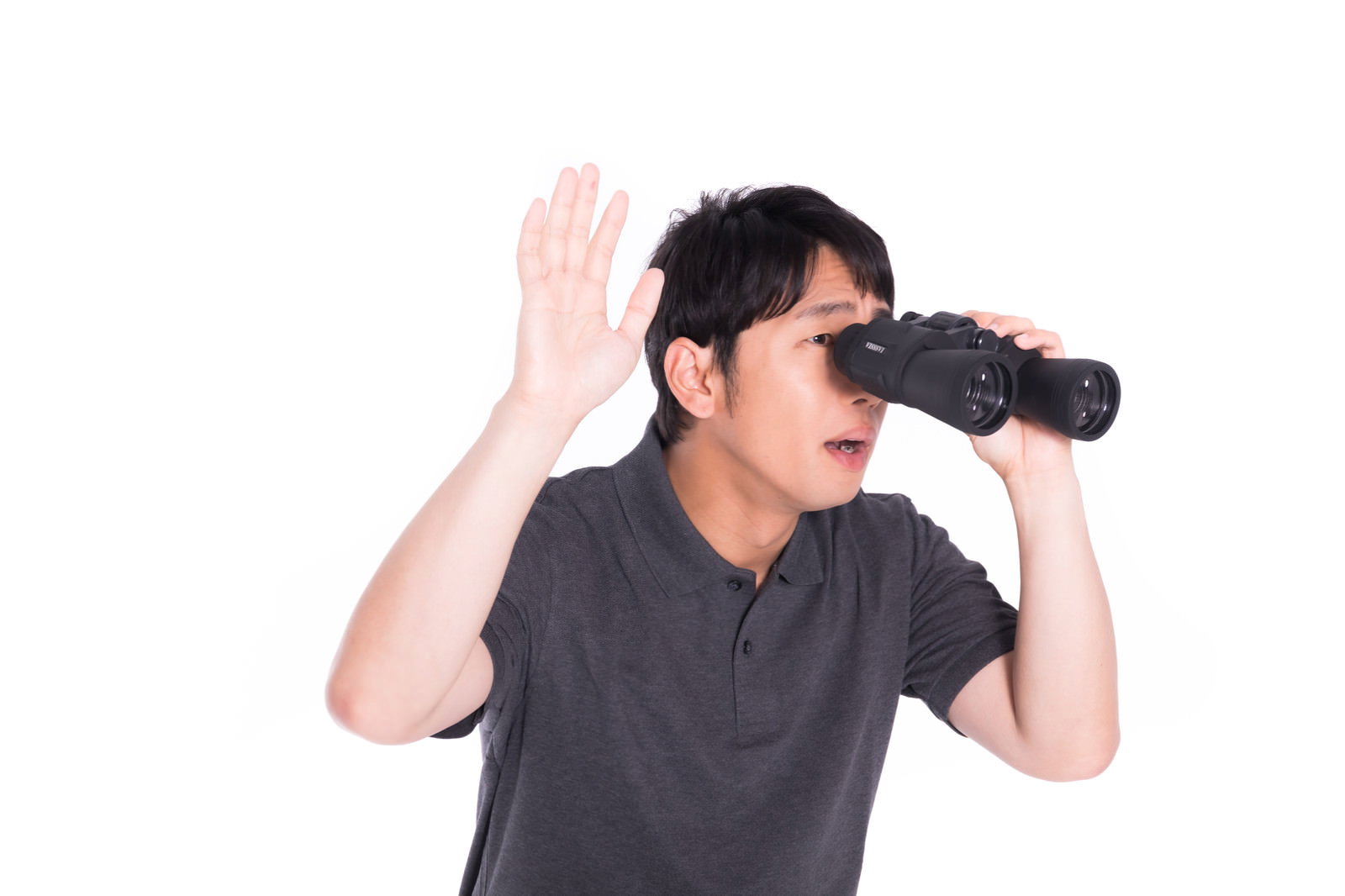 双眼鏡を覗きながら片手を上げるグレーのTシャツの男性［モデル：大川竜弥］